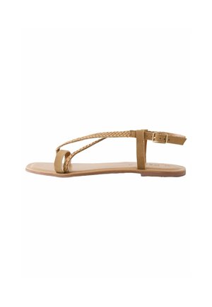 Flat sandal with light brown braided straps, smooth sole, and adjustable ankle buckle. Features minimalist design and open-toe style.