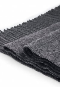 Tissu en feutre gris avec une texture douce, présentant un design superposé avec un bord côtelé et une surface lisse. Le matériau semble durable et polyvalent.