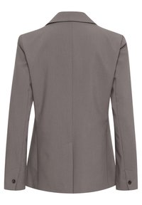 Šedý upravený blazer se strukturovaným límcem, dlouhými rukávy a knoflíkovými detaily na manžetách. Hladká texturovaná tkanina s přiléhavým siluetou.