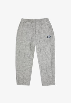 Grå quiltede sweatsbukser med elastisk talje, der har lodrette syninger og et blåt broderet logo på venstre ben.