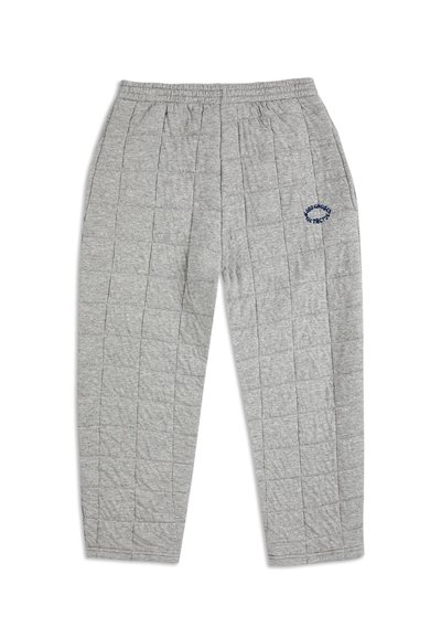 Grå vadderade joggingsbyxor med elastiskt midjeband, med vertikala sömmar och en blå broderad logotyp på vänster ben.