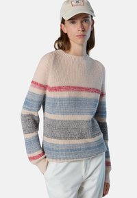 Maglione lavorato a maglia in morbido beige con strisce orizzontali in rosso, blu e grigio. Presenta una texture a coste e un collo a giro.