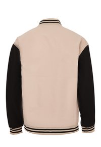 Vista posteriore di una giacca bomber caratterizzata da un corpo beige, maniche nere e polsini e colletto a righe. Texture del tessuto liscia.