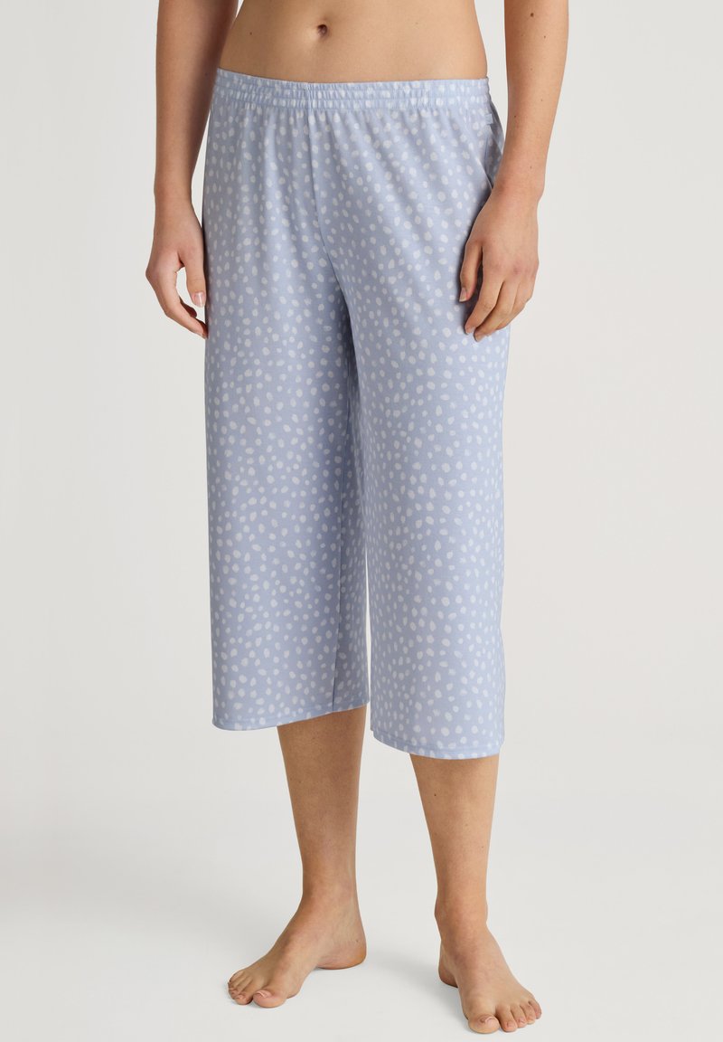 Light blue cropped pajama pants in soft fabric, featuring white polka dot patterns, elastic waistband, and a relaxed fit.