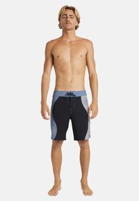 Črno-sivi kratki hlače za desko z modrim pasom v kontrastni barvi. Imajo zavezovanje z vrvico in grafiko sončnega žarka na strani.