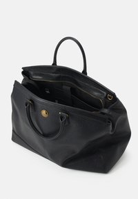 Sac fourre-tout en cuir noir avec deux poignées, dessus ouvert montrant un compartiment intérieur zippé et un emblème doré à l'avant.