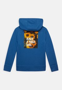 Sweat à capuche bleu avec un grand imprimé de tournesols et le texte "HAVE A NIKE DAY." au dos. Doté d'une capuche avec cordon de serrage et de poignets côtelés.