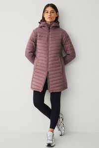 Gewatteerde, knielange jas in zachte mauve, met een rits aan de voorkant, capuchon en horizontale stiksels. Gecombineerd met zwarte leggings en lichte sneakers.