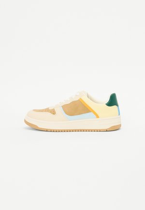 Sneakers with a beige leather and suede upper, featuring yellow, blue, and green accents. Flat rubber sole with a textured pattern.