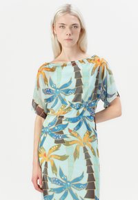 Flerfarget kjole med blomstermønster og blå og oransje detaljer. Laget av lett, gjennomsiktig stoff; av-øverste design.