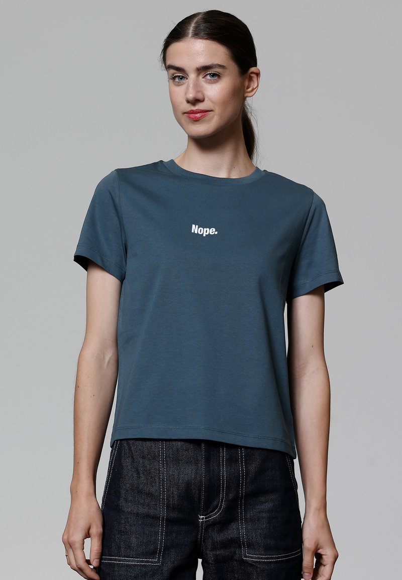 Türkisfarbiges Baumwoll-T-Shirt mit rundem Halsausschnitt, kurzen Ärmeln und weißem Text "Nein." auf der Brust. Glatte Textur.