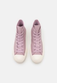 Wysokie trampki z jasnofioletowej skóry z białym gumowym noskiem. Posiadają sznurowany design i gładką teksturę na całej powierzchni.