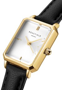 Goldfarbener rechteckiger Chronograf mit einem weißen gemusterten Zifferblatt, einem schwarzen strukturierten Lederarmband und einer silbernen Krone. Verfügt über minimalistische Stundenmarkierungen.