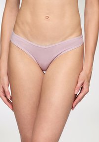 Mutande bikini rosa chiaro con una texture liscia, design a vita bassa e fascia larga. Presenta cuciture minime e nessun motivo visibile.