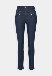 Jeans de mezclilla oscura con cinturilla alta, que cuentan con tres botones en la parte frontal, bolsillos laterales y detalles de costura visibles. Corte recto.
