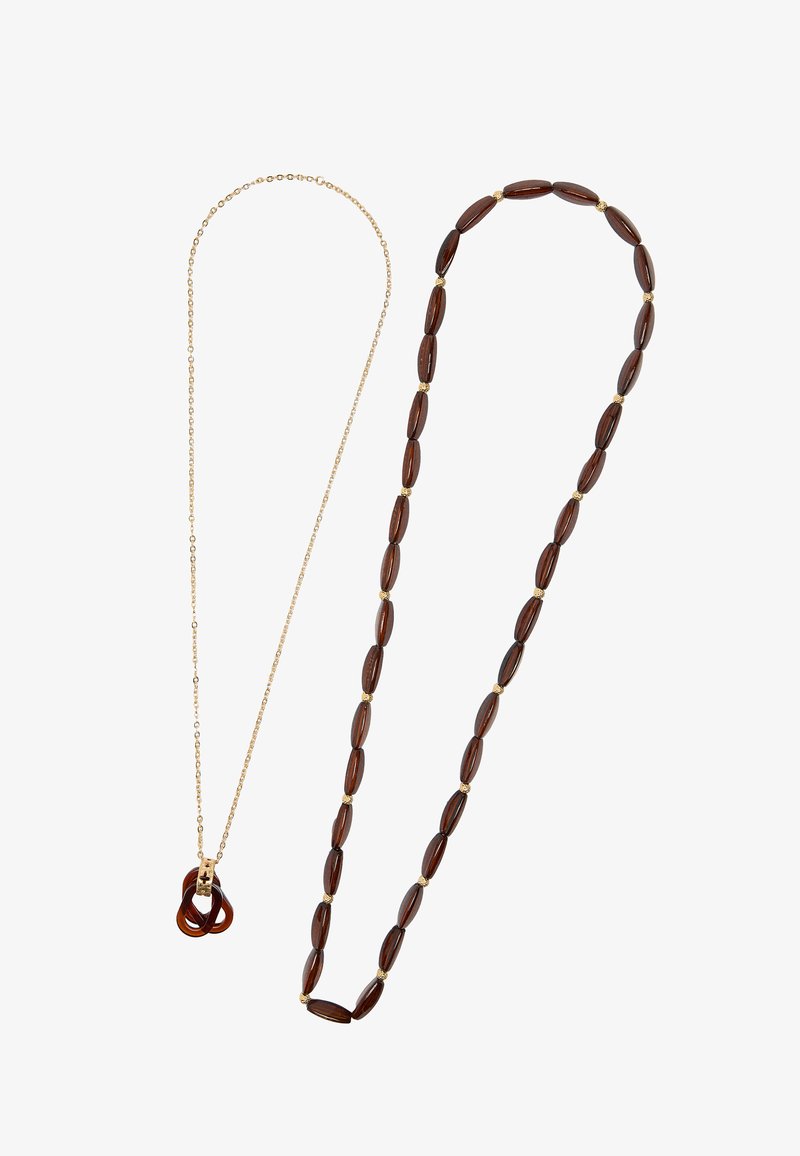 Złoty naszyjnik z brązowym zawieszką z żywicy oraz drugi naszyjnik z owalnymi, ciemnobrązowymi koralikami z złotymi akcentami.