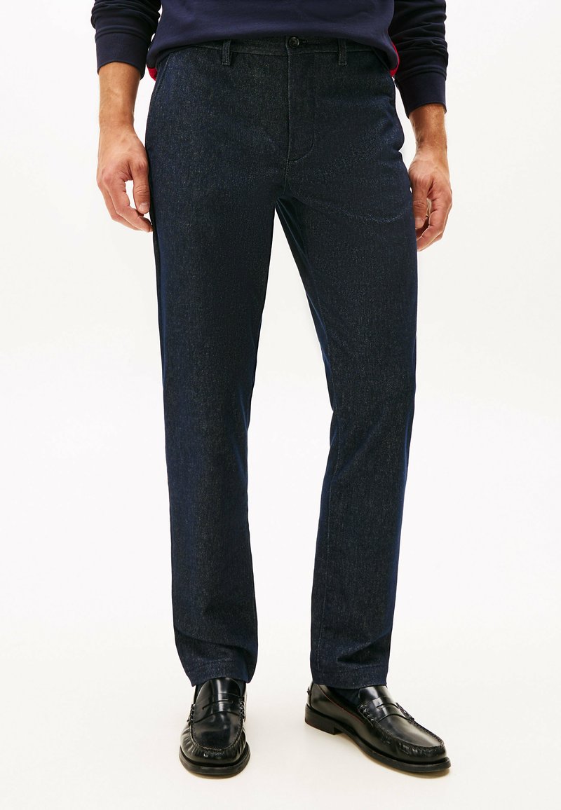 Donkerdenim broeken met een subtiele textuur, rechte pasvorm, voorkruiszakken en een klassieke knoopsluiting, gecombineerd met zwarte schoenen.