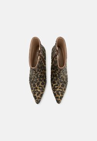 Špičaté kotníkové boty s leopardím vzorem. Texturovaná černá a zlatá látka s bočním zipem. Úzký tvar a elegantní design.
