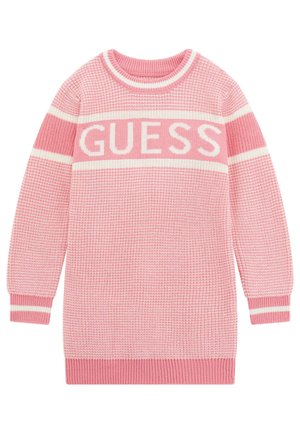 Rosa stickad tröja med ett brett vitt band med texten "GUESS". Ribbad halsringning, ärmslut och fåll; textil med varierande nyanser av rosa.