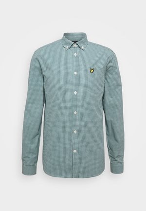 Groen-wit geruit overhemd met lange mouwen en knopen, voorzien van een spitse kraag en een geel vogel-logo op de borst.