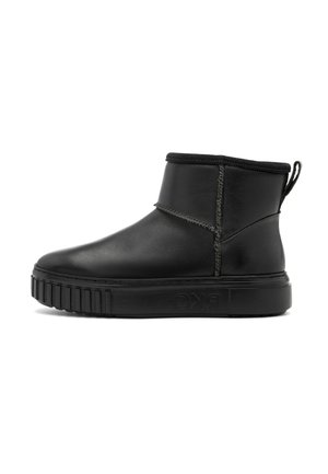 Botines de cuero negro con suela de goma estriada, punta redondeada y detalle de costura elástica. Presenta una cinta en la parte posterior para poner y quitar fácilmente.