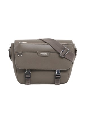 Graue Lacoste Crossbody-Tasche mit Frontklappe, silbernen Schnallenverschlüssen und verstellbarem Schulterriemen.