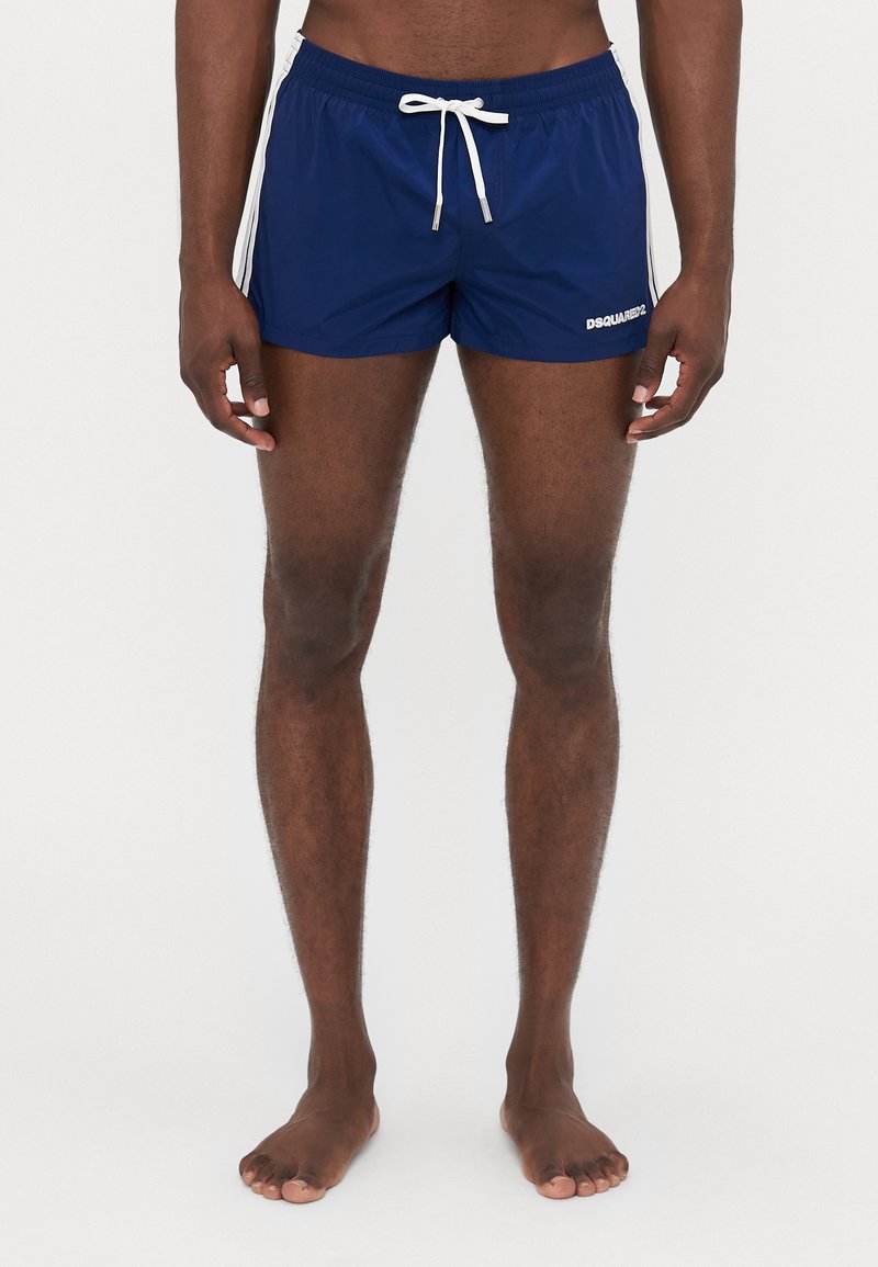 Shorts de bain navy avec des bandes latérales blanches, ceinture élastique et cordon de serrage. Présente le logo "DSQUARED2" sur la jambe gauche.