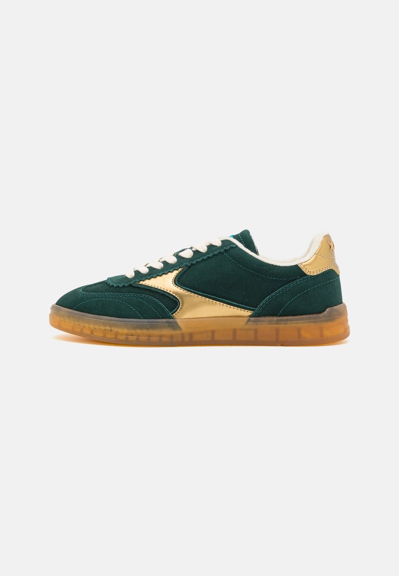 Green suede sneaker featuring a gold metallic side panel, white laces, and a translucent gum sole. Rounded toe and cushioned collar.
