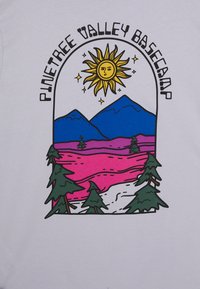 Tricou grafic cu un soare, munți și copaci în culori vii, având textul "Pinetree Valley Basecamp" într-o arcadă curbată. Fundal alb.