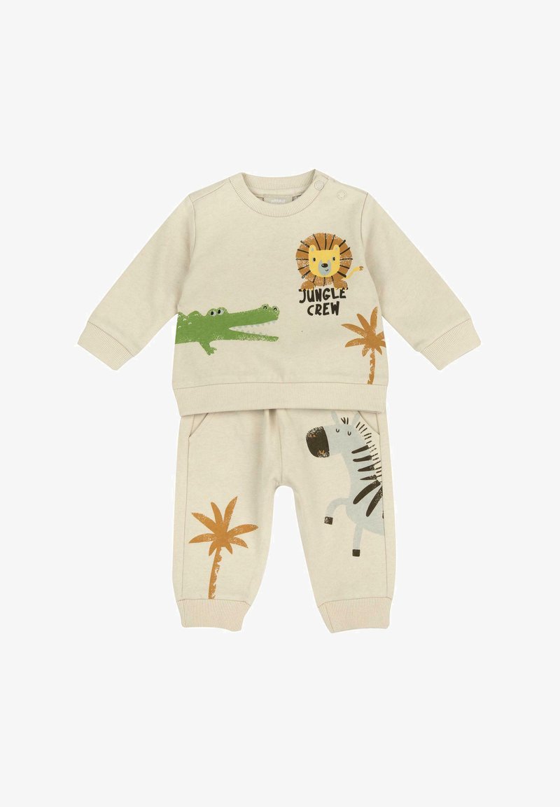 Ensemble beige pour enfants comprenant un haut à manches longues avec des imprimés de lion et de crocodile, et un pantalon de survêtement avec des motifs de zèbre et de palmiers. Matière en coton.