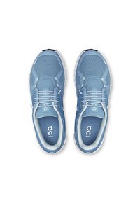 Baskets de sport bleu clair en tissu mesh, avec des panneaux texturés et des accents blancs. Équipées de lacets élastiques et d'un col rembourré pour le confort.