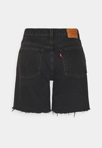 Black denim shorts with frayed hem, featuring two back pockets and a brown leather label at the waistband. Classic five-pocket design.