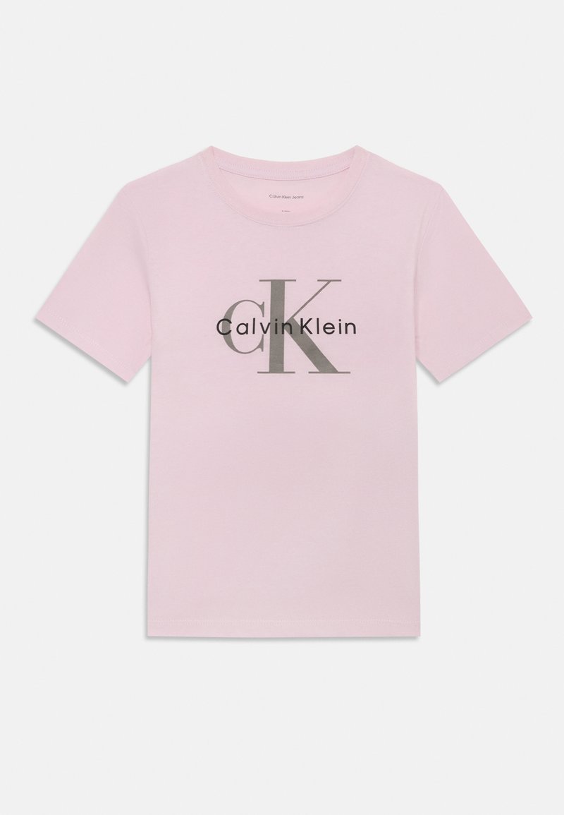 Rozā kokvilnas T-krekls ar īsām piedurknēm, ar pelēku logo dizainu, kurā ir rakstīts "Calvin Klein" un stilizētais "CK" priekšpusē.
