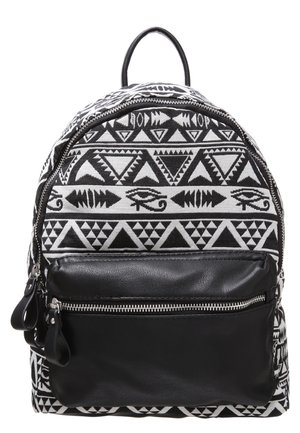 Rucksack mit schwarz-weißen tribal-geometrischen Mustern und Auge des Horus, vorne schwarze Ledertasche mit silbernem Reißverschluss.