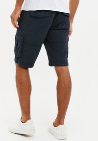 Pantaloni cargo navy realizzati in cotone, con molteplici tasche e una vestibilità rilassata, dotati di tasche laterali e posteriori per una maggiore praticità.