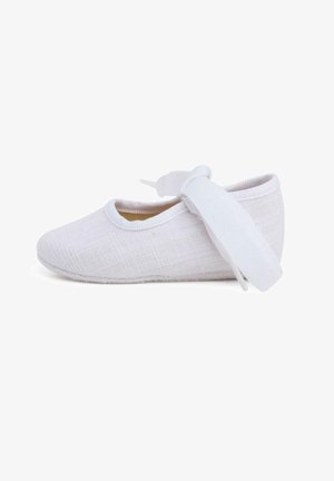 Ballerine blanche en tissu doux et texturé, avec un bout rond et un ruban assorti pour un maintien sécurisé. Semelle flexible pour un confort optimal.