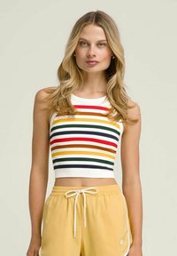 Top corto a rayas con textura acanalada, en colores rojo, verde, amarillo y azul marino, con escote redondeado. Combinado con pantalones cortos amarillos.