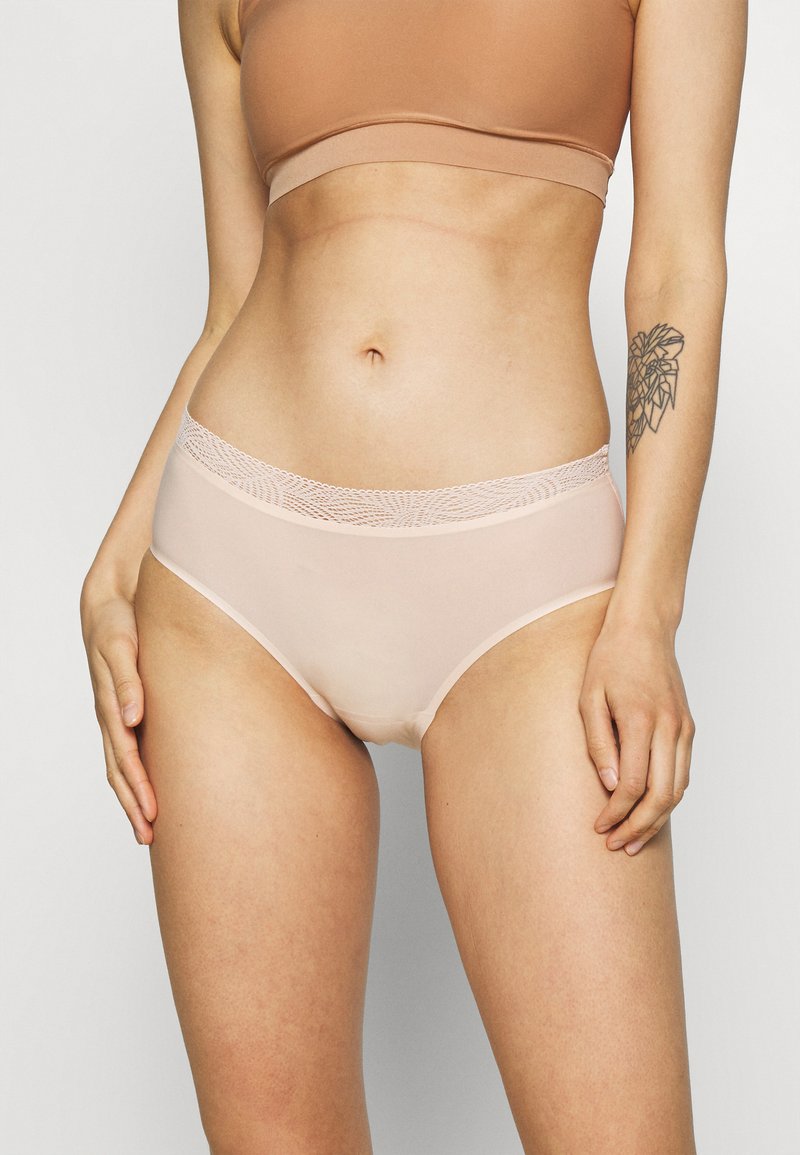 Lys beige høyt liv undertøy med en waistline med blondeakenter, glatt stoff, og en sømløs design for komfort og passform.
