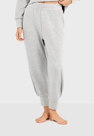 Grijze joggers van een zachte katoenmix, met een trekkoord in de taille, taps toelopende benen en zijzakken. De textuur lijkt glad en casual.