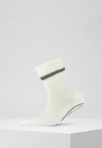 Calzini in misto cotone color écru, con un bordo a righe grigie, trama a coste e suola con puntini antiscivolo per una maggiore aderenza.
