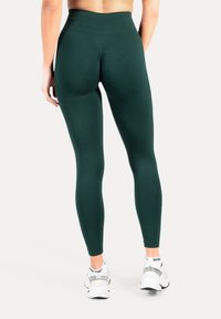 Donkergroene legging met een hoge tailleband, gemaakt van rekbare stof, met een gladde textuur en een aansluitend ontwerp.