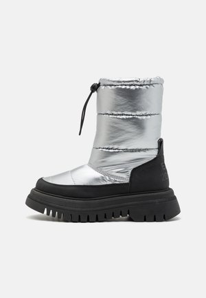 Ασημένια υφασμάτινη μπότα αστραγάλου με μαύρη καουτσουκένια σόλα, υφή στην επιφάνεια, κλείσιμο με κορδόνια στο επάνω μέρος και ανάγλυφη λεπτομέρεια στο πλάι.