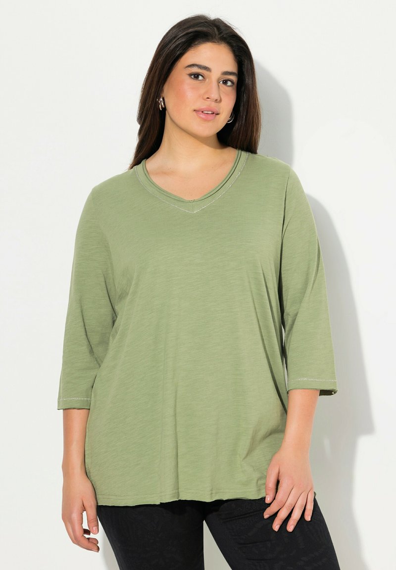 Zelený, lehký, dlouhý rukáv top s výstřihem do V, se subtilními detaily šití. Volný střih se pohodlně přizpůsobuje tělu.