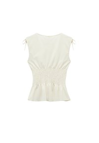 Witte, gestructureerde peplumtop met elastische smock aan de taille, korte mouwen die op de schouders zijn geknoopt, en een ronde halslijn.