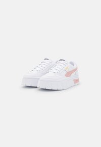 Białe sneakersy z masywną platformą, z różowymi akcentami i teksturowanym wierzchem. Posiadają logo na języku i boku.