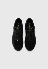 Mustad mustad muste, millel on tekstureeritud kangast ülemine osa, ehitud sädelusega, ümmargused paelad ja pehmendatud krae. Siseosas on suurus 37.