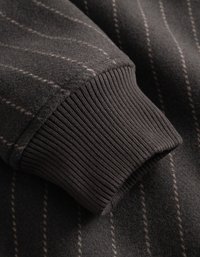 Donkergrijze wollen mouw met dunne verticale lichte strepen en een strak rib gebreid manchet.