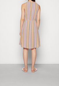 Vestido sin mangas con cintura entallada, que presenta un patrón zigzag multicolor en tonos pastel, hecho de una tela ligera, hasta la rodilla.