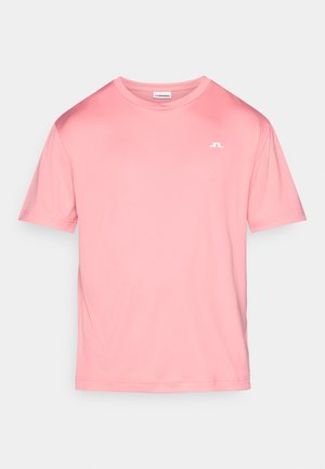 Rózsaszín rövid ujjú póló, sima anyagból készült. Klasszikus kerek nyakkal és a bal felső oldalon egy kis fehér logóval rendelkezik.