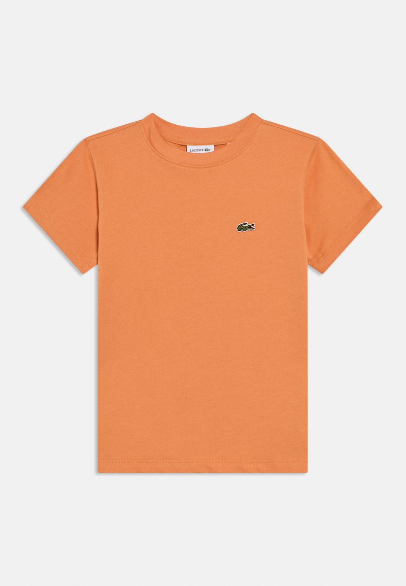 Πορτοκαλί βαμβακερό μπλουζάκι με στρογγυλή λαιμόκοψη, κοντά μανίκια και μικρό πράσινο κεντητό λογότυπο στο στήθος. Απλός, μονόχρωμος σχεδιασμός.